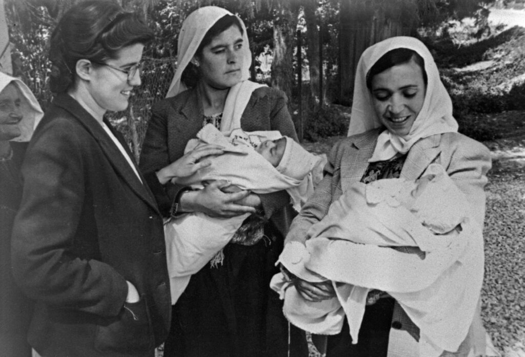 3 women, two holding babies